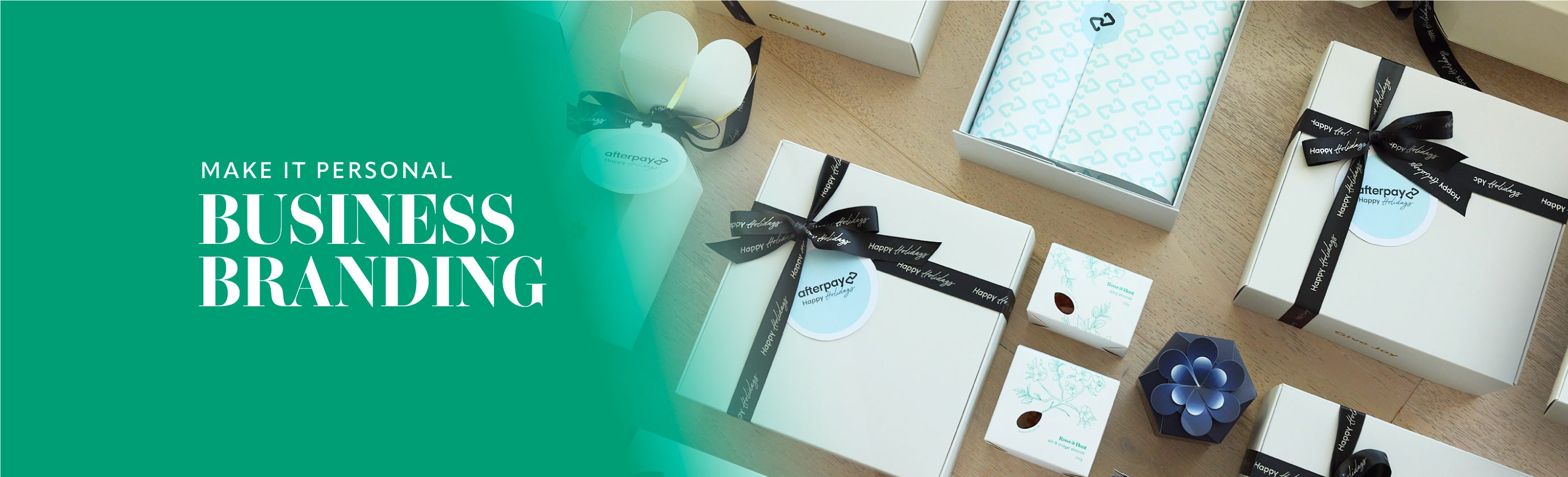 Business branding with gift boxes and decorative items on a wooden surface.