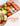 Assorted fruits and a box of chocolates on a white surface with 'Gift Delicious' text.