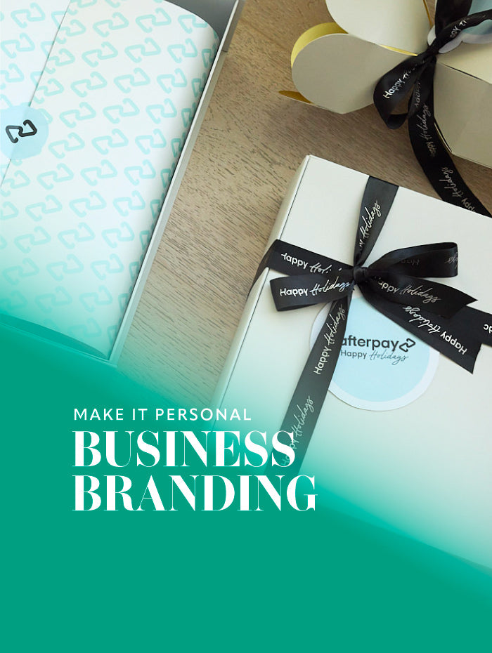 Gift box with a bow and 'Afterpay' label on a wooden surface, with text 'Make it Personal Business Branding' on a teal gradient background.