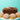 Chocolate loaf cake with cookies and small cupcakes with colorful sprinkles on a turquoise background
