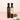 Two bottles of Lugia's Fine Foods olive oil and balsamic vinegar on a pink background.