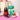 Bottle of champagne, cookies, and chocolates on a pink surface with a gift bag in the background.